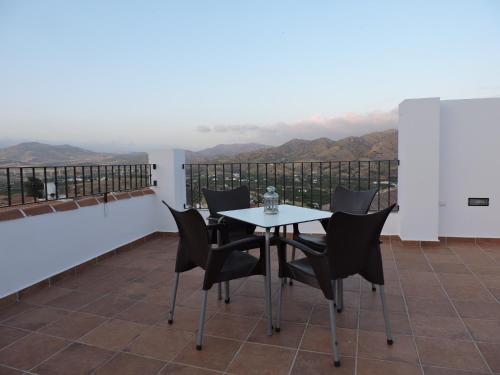 a table and chairs on a balcony with a view at Hostal Delia in Alora