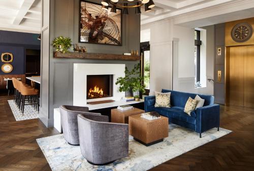 a living room with a blue couch and a fireplace at The Whitney Hotel Boston in Boston