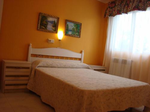 a bedroom with two beds in a room with a window at Pensión Mariaje in Celorio