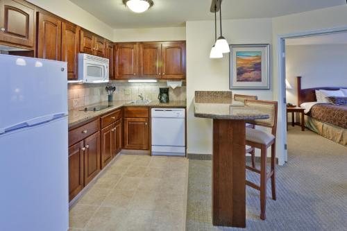 a kitchen with wooden cabinets and a island in a room at Staybridge Suites Indianapolis-Carmel by IHG in Carmel