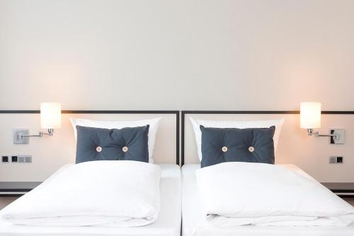 a bedroom with two beds with blue pillows at Seminaris Hotel Bad Honnef in Bad Honnef am Rhein