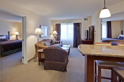 a hotel room with a bed and a living room at Staybridge Suites Indianapolis-Carmel, an IHG Hotel in Carmel