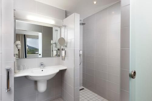 a white bathroom with a sink and a mirror at Seminaris Hotel Bad Honnef in Bad Honnef am Rhein