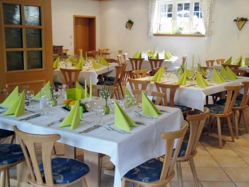a room with tables and chairs with green napkins at Wein Lodge Durbach - Schlossblick in Durbach