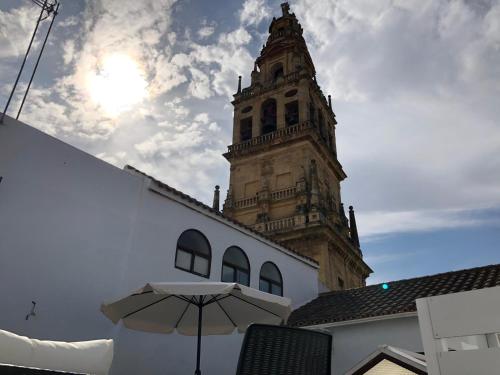 a building with a clock tower and an umbrella at La Torre in Córdoba