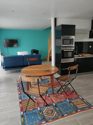 - une table et deux chaises dans le salon dans l'établissement Chaumière d'Albâtre - Gîte-Entre terre et Mer, à Ourville-en-Caux