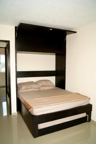 a bed in a room with a black bed frame at Penthouse con Jacuzzi en Acapulco Diamante in Acapulco
