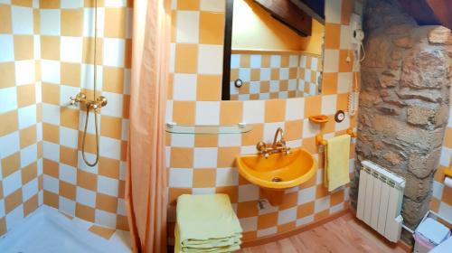 a bathroom with a yellow sink and a shower at Cal Sams in Olopte