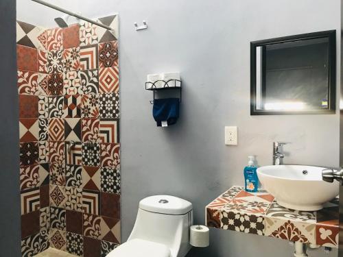 La salle de bains est pourvue de toilettes et d'un lavabo. dans l'établissement CASA MALIX Puerto Morelos, à Puerto Morelos