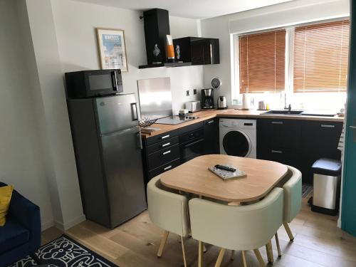 a kitchen with a table and a refrigerator and a sink at Entre mer et commerces in Wimereux