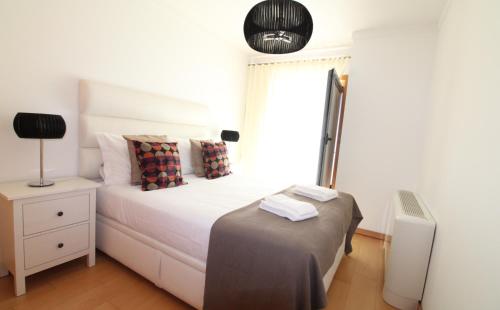 a bedroom with a white bed and a window at Parque das Nacoes River view ,free wifi in Lisbon