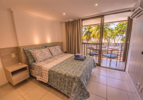 sypialnia z łóżkiem i dużym oknem w obiekcie Luxor Cabo Branco Home Service w mieście João Pessoa
