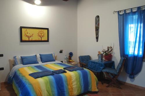 a bedroom with a bed and a table and chairs at Agriturismo Monte Majore in Siliqua