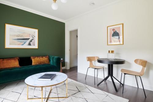 a living room with a green couch and a table at Sonder St Johns Garden in London