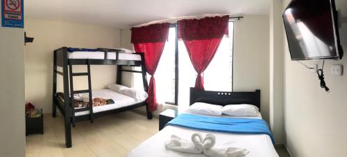 a bedroom with two bunk beds and a window at Hotel Dulces Sueños in Santa Rosa de Cabal