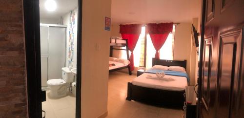 a small bedroom with a bed and a bathroom at Hotel Dulces Sueños in Santa Rosa de Cabal