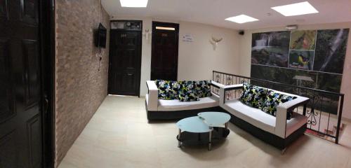 a living room with two couches and a table at Hotel Dulces Sueños in Santa Rosa de Cabal
