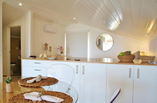 una cocina con armarios blancos y una mesa con 2 cestas. en 374 CK Seaside Guest House, en Vila Franca do Campo
