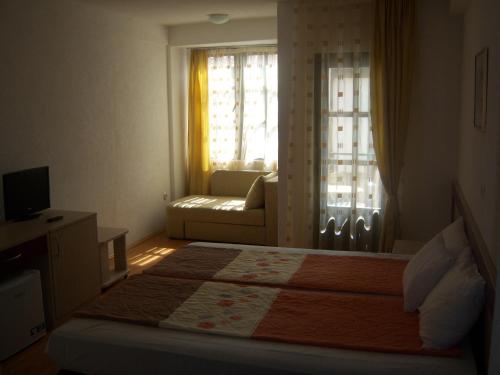 a bedroom with a bed with a couch and a window at Apartmani Marija in Ohrid