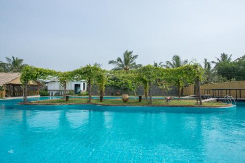 a swimming pool with blue water in a resort at Amaluna Resorts in Negombo