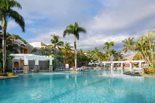 a pool at a resort with palm trees at Casa Marina Beach & Reef All Inclusive in Sosúa