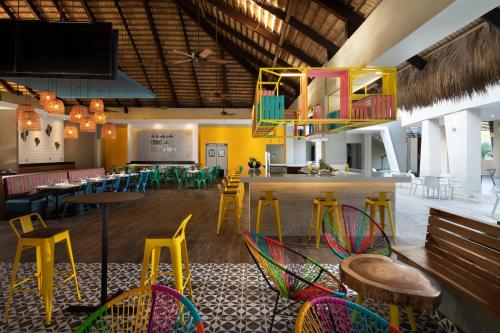 a restaurant with colorful chairs and tables and a bar at Casa Marina Beach & Reef All Inclusive in Sosúa