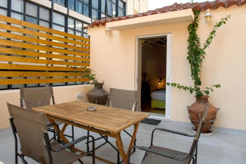 a patio with a wooden table and chairs at Metis Athens Suites in Athens