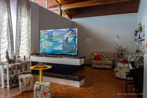 a living room with a large flat screen tv at Bela Curitiba Hostel in Curitiba