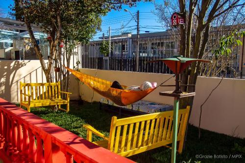 a man sleeping in a hammock in a yard at Bela Curitiba Hostel in Curitiba