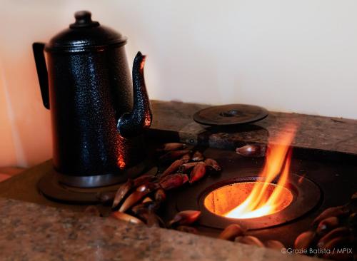 a tea kettle on top of a stove with flames at Bela Curitiba Hostel in Curitiba
