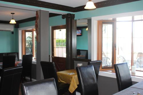 a dining room with chairs and a table and windows at Tiki Shores Inn & Suites in Penticton