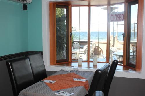 a dining room with a table and a view of the ocean at Tiki Shores Inn & Suites in Penticton
