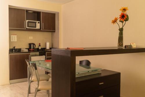 a kitchen with a table and a vase with flowers at Icaro Suites in Buenos Aires