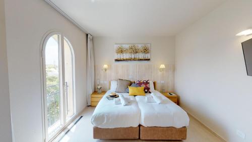 耶路撒冷的住宿－David Village Residences - Rental Israel，一间卧室设有一张大床和一个大窗户