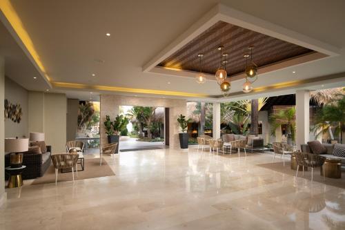 a lobby with chairs and tables in a building at Casa Marina Beach & Reef All Inclusive in Sosúa