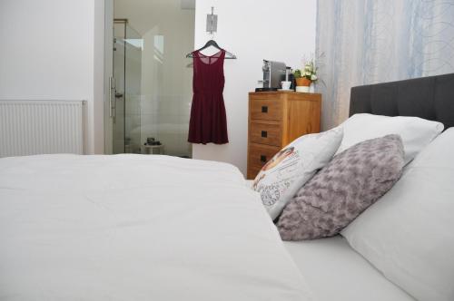 a bedroom with a bed and a dress hanging on a rack at Six! Eat Work Sleep in Brühl