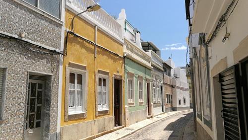um beco numa cidade velha com edifícios em Casa Magica em Olhão