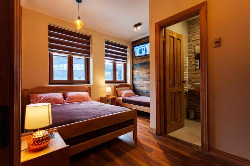 1 dormitorio con cama, ventana y espejo en Hostal Boutique Patagonia Mística en Punta Arenas