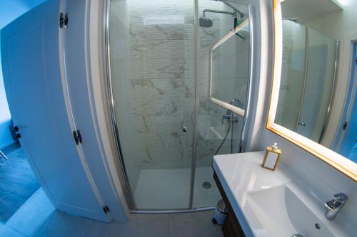 y baño con ducha y lavamanos. en Morze-kwatery Apartament Bel Mare, en Międzyzdroje