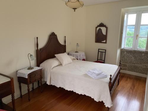 a bedroom with a bed with white sheets and a window at Casa Oceane in Duquezas