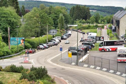 a busy street with cars parked on the side of a road at Open Source à l'entrée du Circuit! in Stavelot