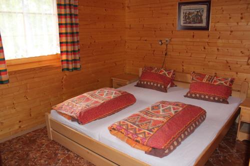 2 letti in una camera con pareti in legno di Apartmány a Chalupa Tara a Albrechtice v Jizerských horách