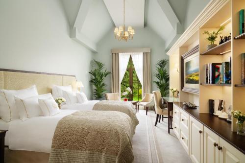 a bedroom with two beds and a christmas tree at Grantley Hall in Ripon