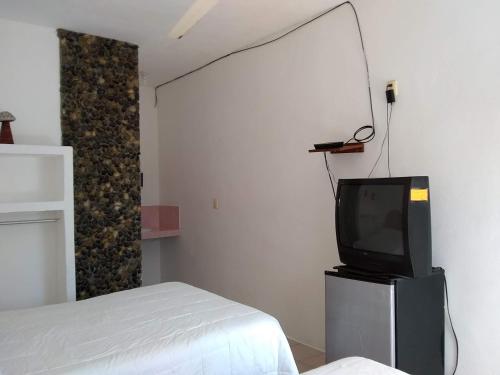 a room with a bed and a tv in a room at Hotel Villas del Rey in Chachalacas