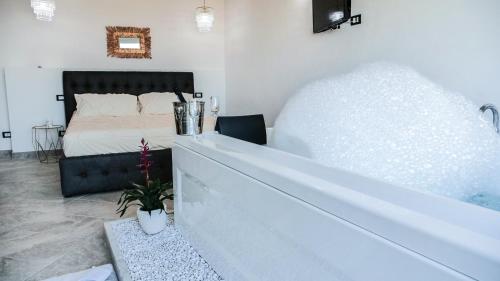 a bedroom with a large bed and a bath tub at Antico Borgo dei Templi in Agrigento