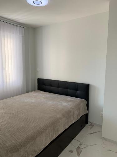 une chambre avec un lit avec une tête de lit noire dans l'établissement Le palladium, à Cannes