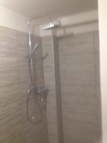a shower with a glass door in a bathroom at Apartman Luca in Nyíregyháza