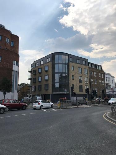 a building with cars parked in front of a street at Elegant Plus Luxury Apartments in London