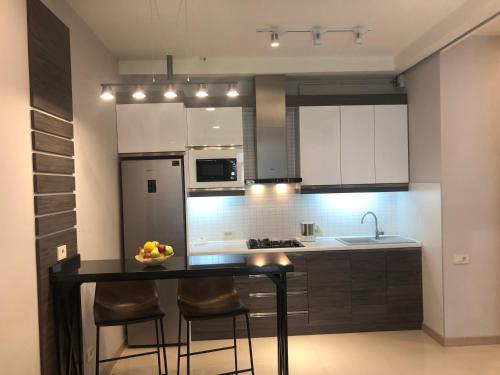 a kitchen with a table with chairs and a bowl of fruit on it at Apartment on Moskovyan 31 in Yerevan