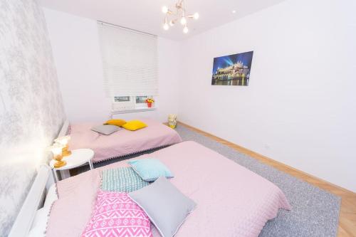 2 camas en una habitación de color rosa y blanco en BIG APARTMENT OLD TOWN p4you pl en Cracovia